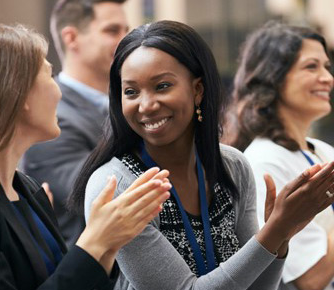 Woman smiling while clapping in a crowd